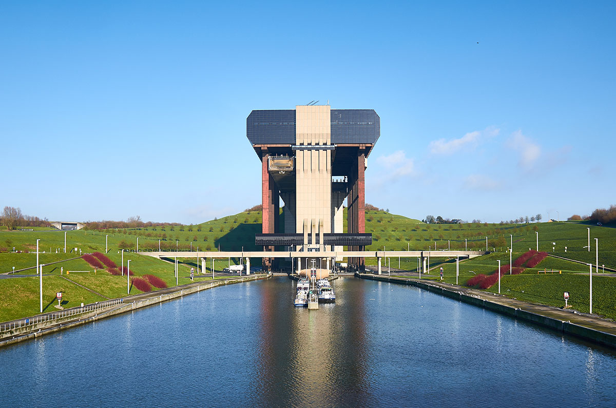 A large canal with a huge boat lift at the end set into green hillside